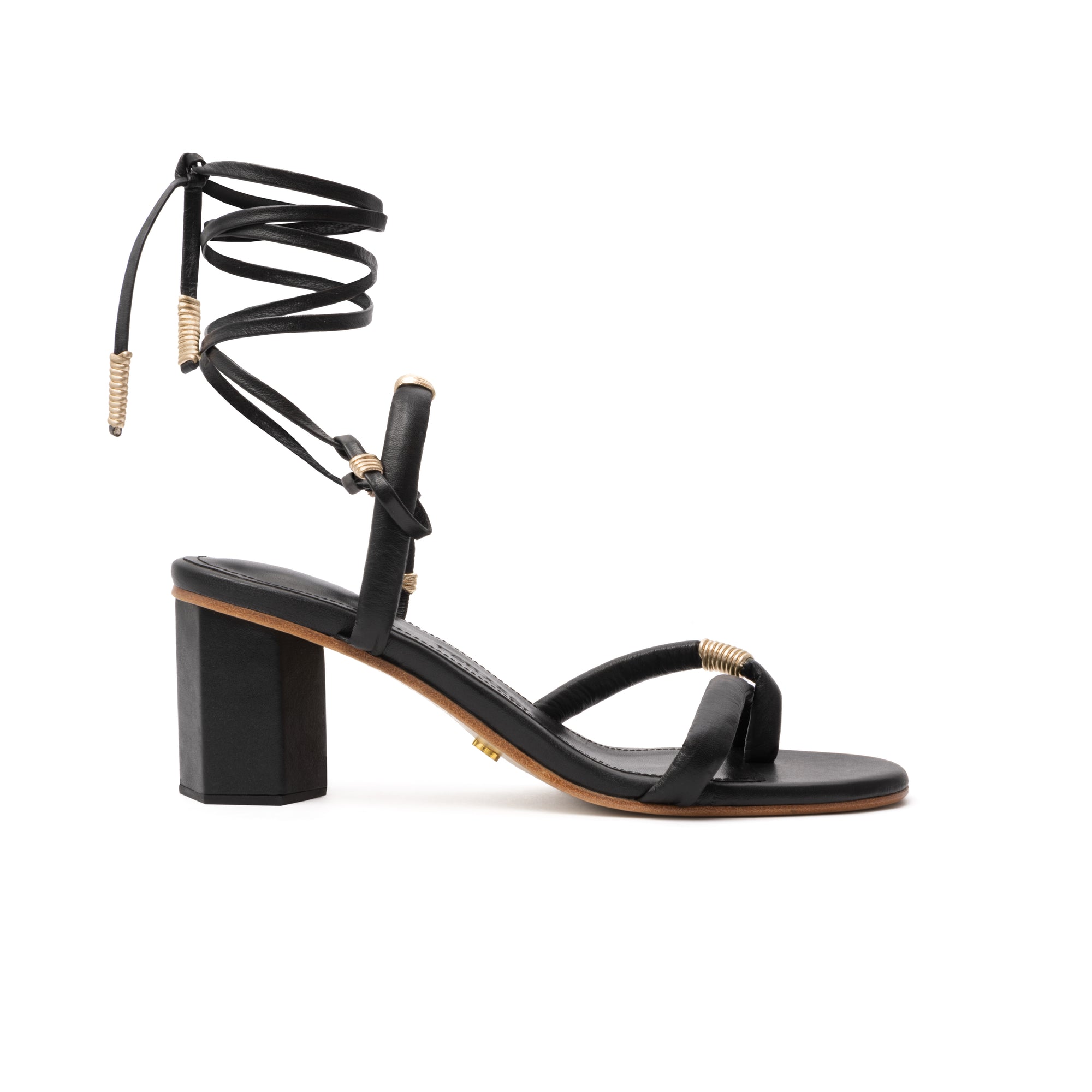 Side view of Ana Sandal showcasing its 5.5-inch hexagon wooden heel, sleek leather wrap-around ankle straps, and delicate front straps with metallic gold threading.